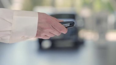 Yeni arabadan erkek müşteriye anahtarları sunan kadın satıcı