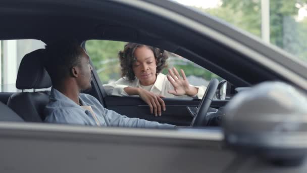 Kobieta sprzedawca samochodów pokazując do męskiego klienta luksusowy samochód — Wideo stockowe