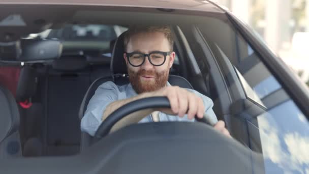 Hombre alegre probando nuevo coche de lujo en el salón moderno — Vídeos de Stock