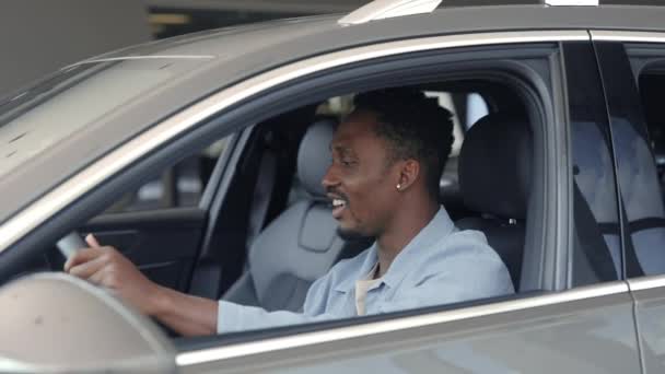 Afrikai férfi tesztelés autószalon vásárlás előtt — Stock videók
