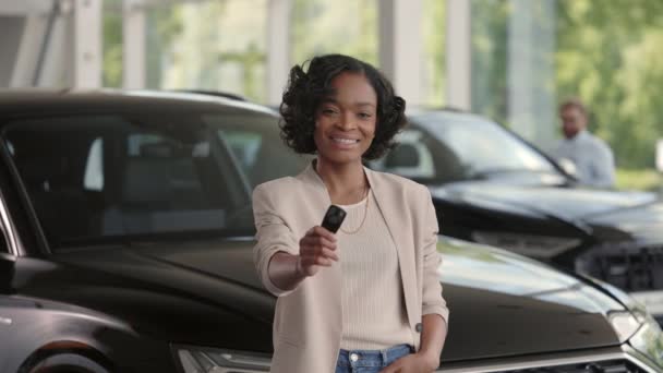 Satisfecho señora africana de pie cerca del coche con llaves en las manos — Vídeo de stock