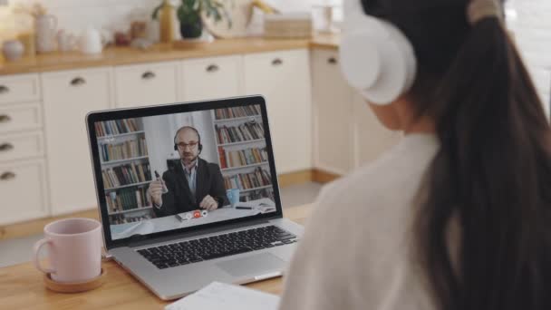 Vrouw met laptop voor videogesprek met mannelijke docent — Stockvideo