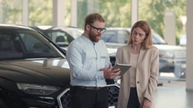 Kadın imza atarken erkek satıcı elinde tablet tutuyor