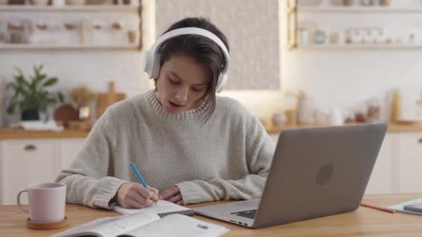 Femme dans les écouteurs en utilisant un ordinateur portable pour l'enseignement à distance — Video