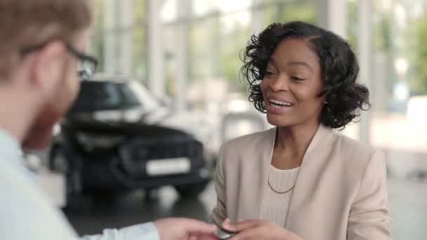 Señora tomando llaves de nuevo auto y estrechando la mano con el vendedor — Vídeos de Stock