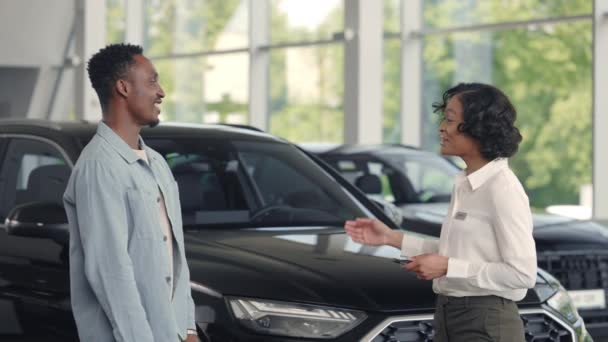 Consultor de coches presentando llaves cliente masculino en el salón — Vídeos de Stock