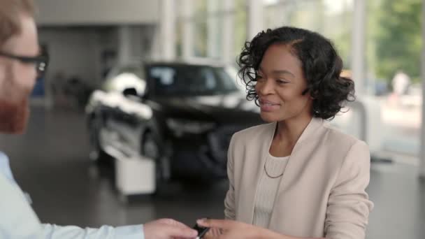 Salesman memberikan kunci dari mobil baru untuk klien perempuan — Stok Video