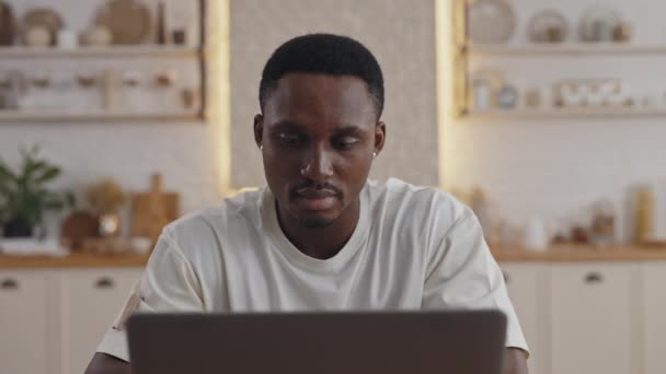 Egy jóképű afrikai férfi portréja, aki laptopot használ a tanuláshoz — Stock videók