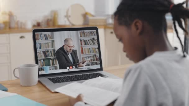 Alumno negro teniendo video lección con el profesor en el ordenador portátil — Vídeo de stock