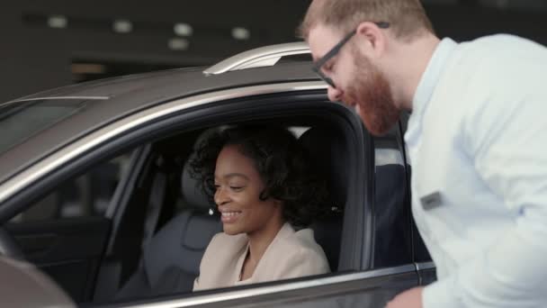 Muž dealer vysvětlující detaily nového vozu na ženské klientce — Stock video