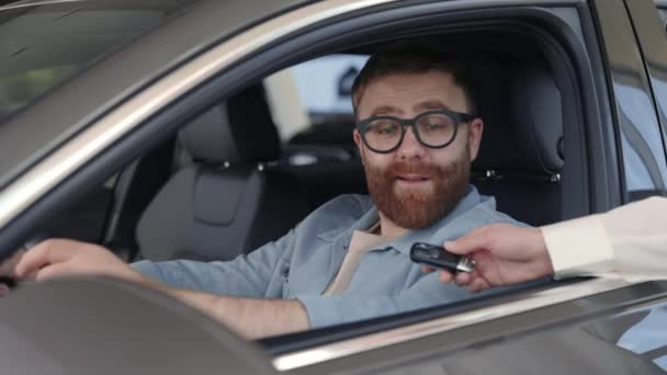 Man zit in nieuwe auto en neemt sleutels van de vrouwelijke verkoper — Stockvideo