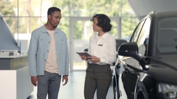 Tablet gerente do sexo feminino trabalhando com o cliente no salão de auto — Vídeo de Stock