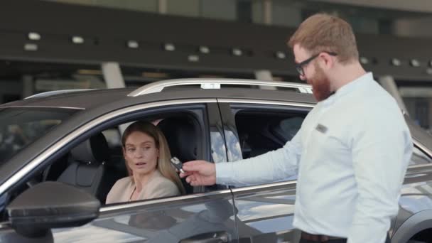 Männlicher Verkäufer übergibt Schlüssel vom Luxusauto an neuen Besitzer — Stockvideo