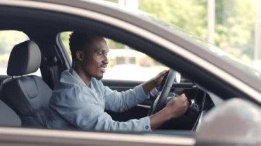 Afrikalı adam kuaförden araba alırken mutlu oluyor.