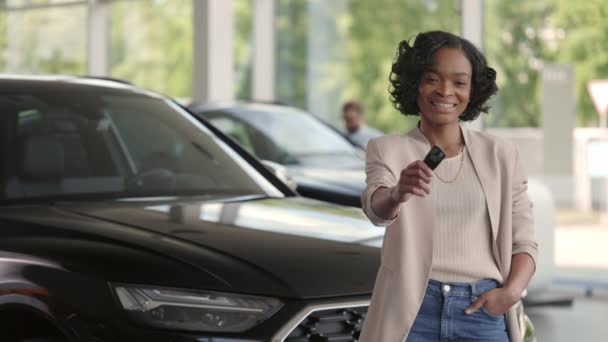 Mujer sonriente posando en el salón con las llaves de su coche nuevo — Vídeo de stock