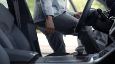 Yeni lüks arabasında oturan mutlu genç adam.