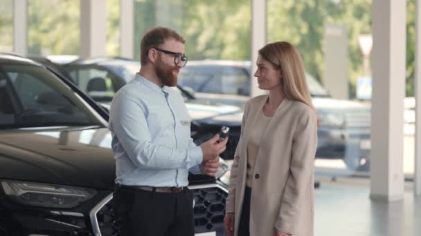 新しい車から女性の所有者へのキーを与えるマネージャー — ストック動画