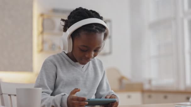 Αφρικανικό παιδί που χρησιμοποιεί σύγχρονα gadgets ενώ κάνει την εργασία — Αρχείο Βίντεο