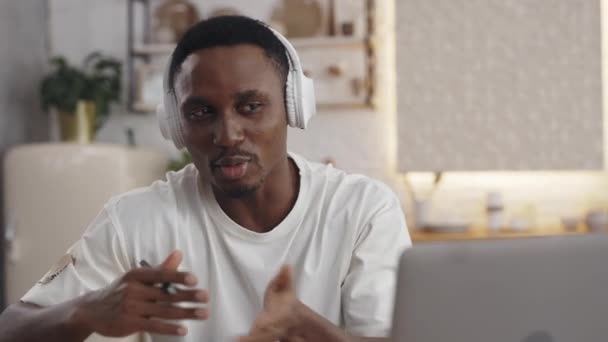Negro chico en auriculares teniendo vídeo lección en portátil — Vídeos de Stock