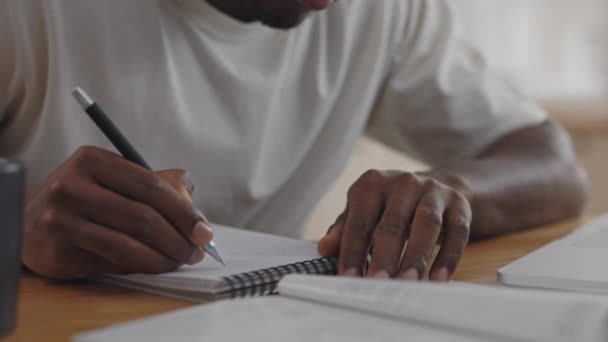 Закрыть африканский студент читает книгу и пишет заметки — стоковое видео