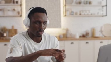 Afrikalı Amerikalı çocuk evde otururken online çalışıyor.