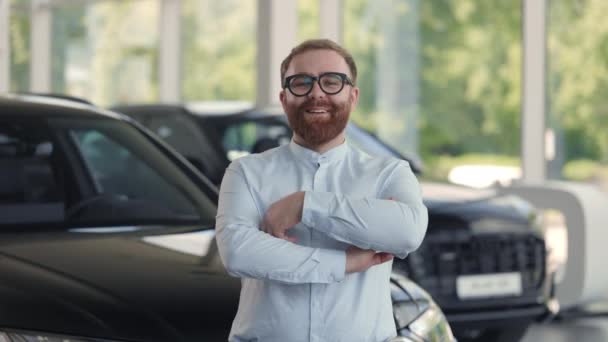 Позитивний чоловічий дилер в окулярах позує в автоцентрі — стокове відео