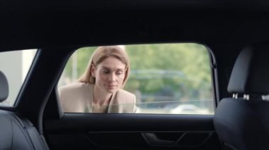 Çekici bir kadın, galeride çeşitli lüks arabaları izliyor.