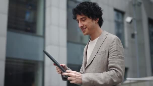 Vista de cámara de movimiento del exitoso hombre de negocios leyendo sus documentos mientras camina por la calle del distrito financiero de la gran ciudad. Concepto de ocupación. — Vídeos de Stock