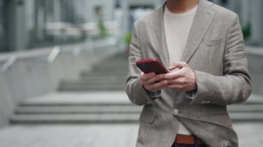 Açık havada mesajlaşan yakışıklı adamın portresi. İş adamı sokakta akıllı telefondan konuşuyor. Ofis çalışanı cep telefonu kavramı dışında konuşuyor.