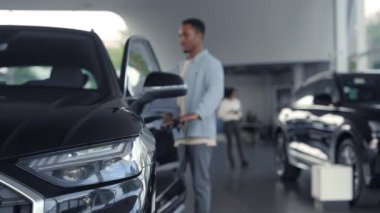 Afrikalı adam test salonu için modern arabanın kapısını açtı.