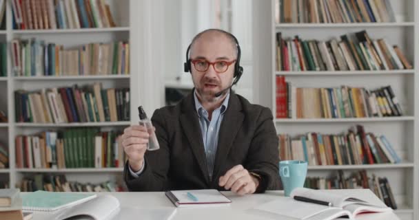 Tutor masculino enseñando a los estudiantes en línea cómo utilizar antiséptico — Vídeo de stock