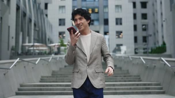 Захватывающий бизнесмен разговаривает по смартфону на городской улице. Счастливый человек, обсуждающий хорошие новости по мобильному телефону на улице. Счастливый бизнесмен празднует победу на удаленном рабочем месте. — стоковое видео