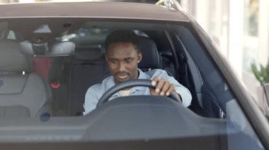 Lviv, Ukrayna - 21 Mayıs 2021: Afrikalı erkek müşteri galeride araba galerisini inceliyor