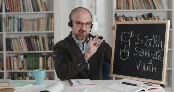 Conférencier en casque enseignant les mathématiques lors d'un appel vidéo — Video