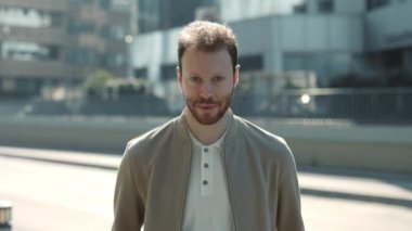 Sokakta dikilen modaya uygun giyinmiş beyaz adam.
