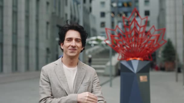 Sentirse tranquilo. Retrato vista del hombre caucásico consciente de pie en la calle y cruzó los brazos mientras posaba ante la cámara con edificios urbanos al fondo. — Vídeos de Stock