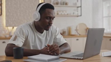 Afrikalı bir adam laptopta eğitici video konferansı yapıyor.