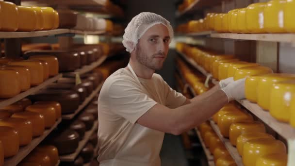 Man die de kwaliteit van kaas controleert die veroudert in het magazijn — Stockvideo