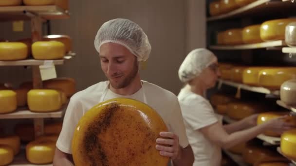 Δύο εργαζόμενοι ελέγχουν την κατάσταση του παλαιωμένου τυριού στο εργοστάσιο — Αρχείο Βίντεο