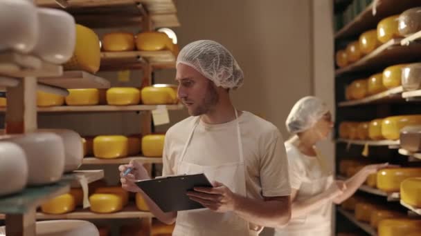 两名乳制品工人控制乳酪头的成熟 — 图库视频影像