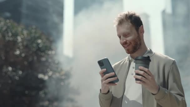 Стильный мужчина с мобильным телефоном, стоя на улице — стоковое видео
