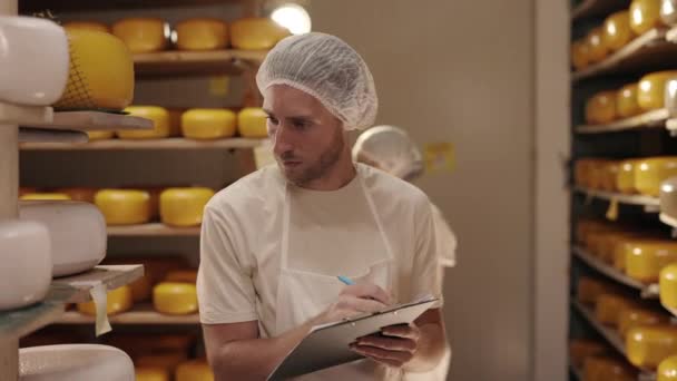 Чоловік пише на кишені під час огляду молочної фабрики — стокове відео