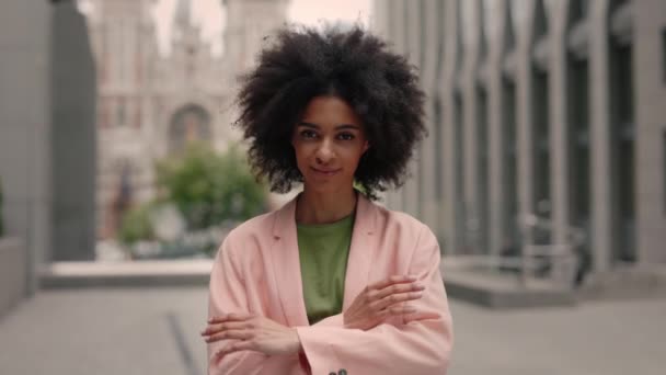 Great mood. Portrait view of the multiracial business woman wearing pink fashionable suit standing arms crossed and feeling great while standing near business centre. — Stock Video