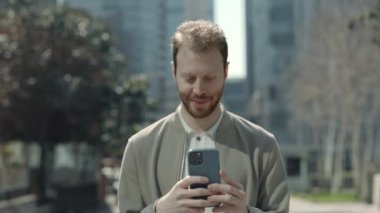 İş adamı cep telefonundaki e-postaları kontrol ediyor.