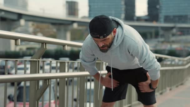 Bărbat de vârstă mijlocie care utilizează aplicația de fitness smartwatch după alergarea în aer liber. Bărbatul cu barbă se simte obosit după antrenamentul în aer liber. Stiluri de viață active, concept tehnologic . — Videoclip de stoc