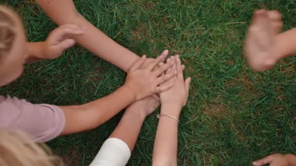 Blandade ras barn och lärare stapling händer i cirkel — Stockvideo