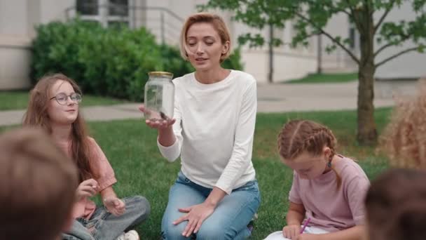 Frau mit Pflanze in der Hand bringt Schulkindern Ökologie bei — Stockvideo