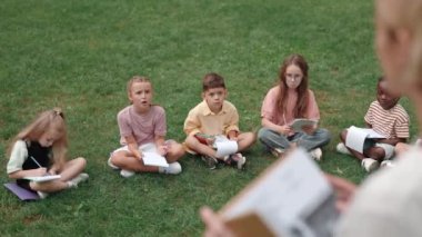 Açık hava dersleri sırasında çeşitli çocuklar sorulara cevap veriyor.