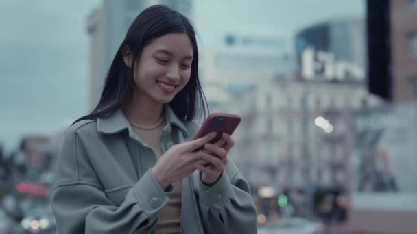 Japonês mulher de pé na rua com móvel em mãos — Vídeo de Stock