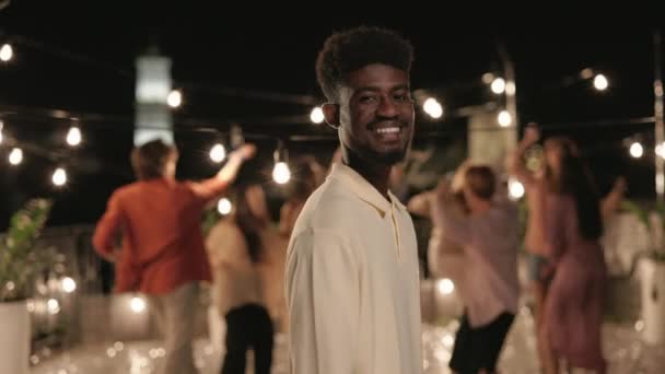 Sorridente uomo africano in posa sulla macchina fotografica durante la festa sul tetto — Video Stock